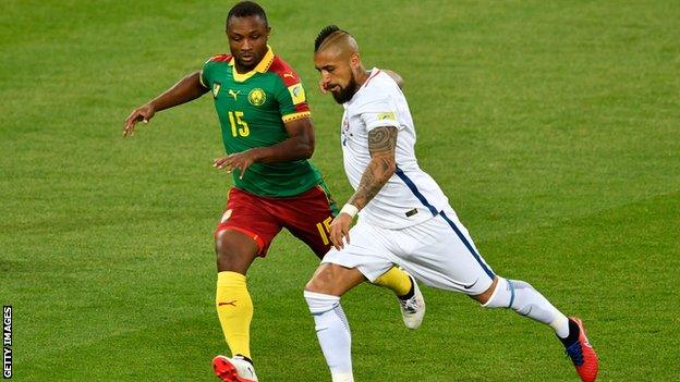 Cameroon's Sebastian Siani (left) battles for the ball with Chile's Arturo Vidal