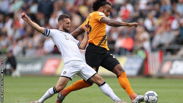 Swansea captain Matt Grimes challenges Hull's Tom Huddlestone
