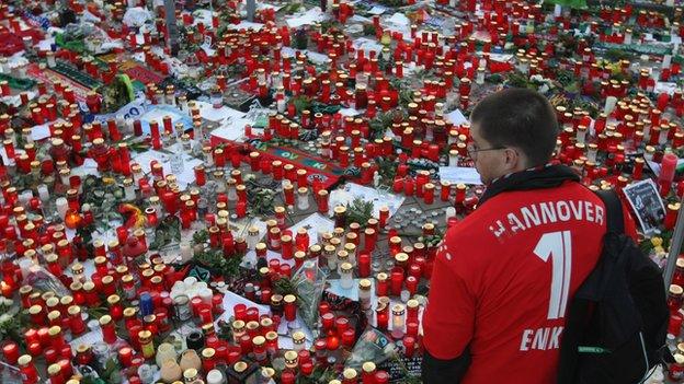 HANOVER, GERMANY - NOVEMBER 15: A fan of the Hannover 96 football club looks at a sea of candles for goalie Robert Enke shortly before a memorial service prior to Enke�s funeral at AWD Arena on November 15, 2009 in Hanover, Germany. Tens of thousands of fans paid their last tribute to Enke, who was also goalie for the German national team, following Enke�s suicide on November 10. (Photo by Sean Gallup/Getty Images)