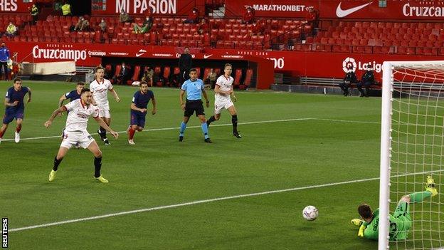 Atletico Madrid keeper Jan Oblak saves Lucas Ocampos' first-half penalty against Sevilla