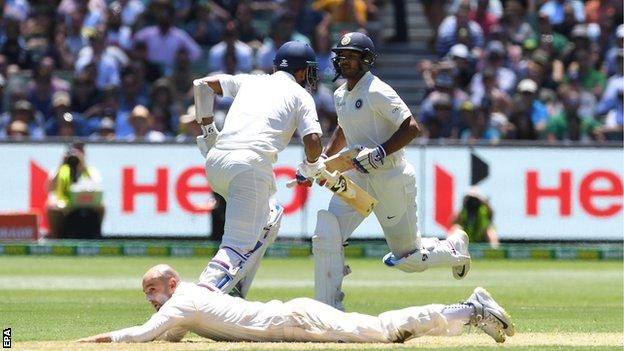 India's Cheteshwar Pujara and Mayank Agarwal run as Nathan Lyon fields