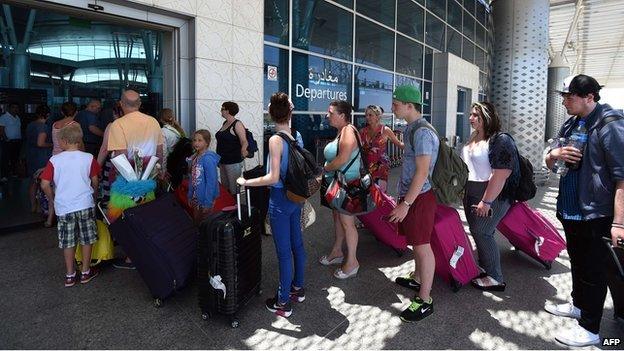 Holidaymakers queue at the departures gate at a Tunisian airport