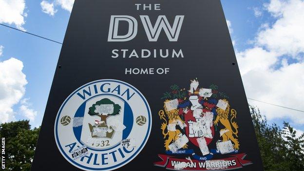 A sign reading: 'The DW Stadium, home of Wigan Athletic'