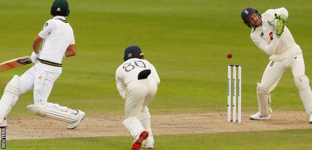 Jos Buttler misses the stumping of Shan Masood