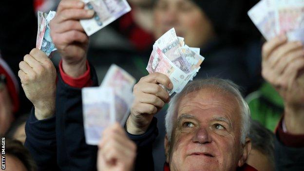 Gloucester fans waved money ate Saracens in reference to their salary cap fine