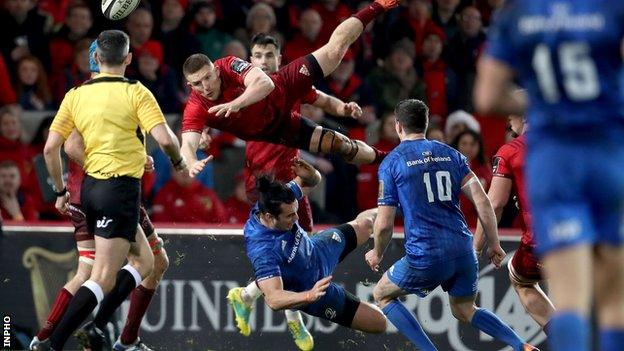 Leinster's James Lowe takes out Munster's Andrew Conway in the air