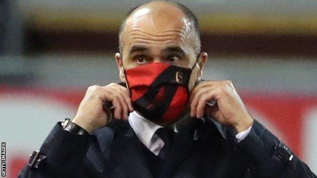 Roberto Martinez adjusts his mask