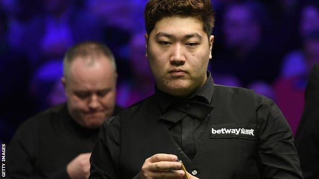 Yan Bingtao chalks his cue