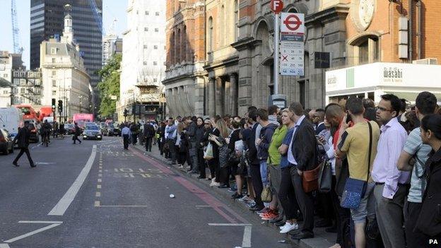 People queue for buses outside Liverpool Street Station, London