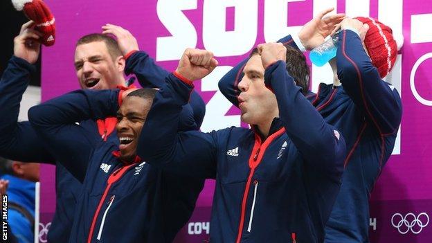 GB four-man bobsled crew watching other crews finish at the Sochi 2014 Winter Games