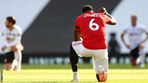 Manchester United's Paul Pogba takes a knee and raises his first before kick-off