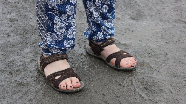 Glaw neu hindda, tybed? Mae'n bwysig gwisgo'n addas ar gyfer y Steddfod // Sandals or wellies? This optimistic lady's taken a gamble on the weather drying out