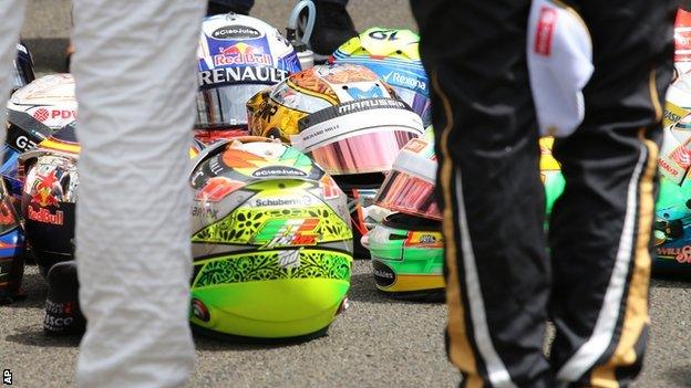 The drivers placed their helmets on the ground before gathering around for the minute's silence. Jules Bianchi's helmet was among them