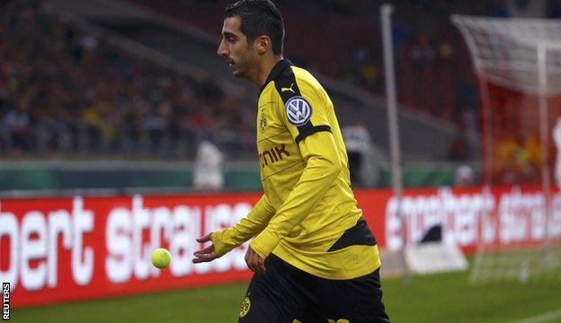 Henrikh Mkhitaryan throws one of the balls off the pitch