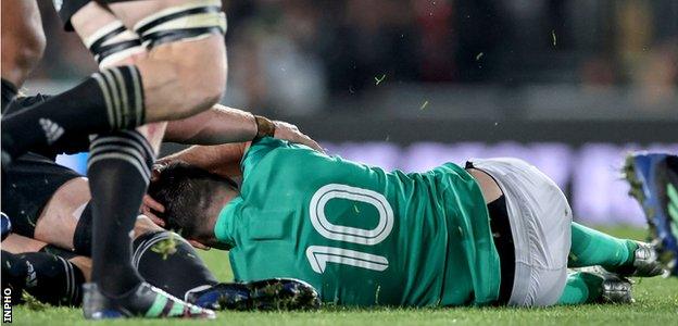 Johnny Sexton clutches his head after colliding with Sam Cane in Auckland