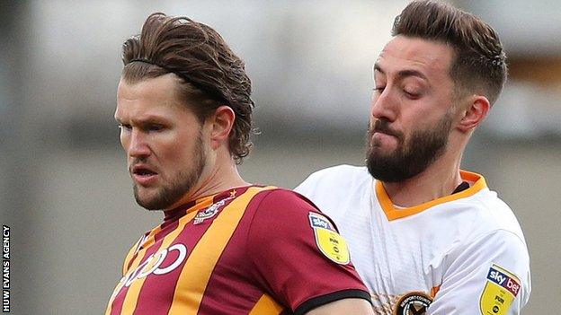 Bradford City's Jake Reeves holds off Josh Sheehan of Newport County