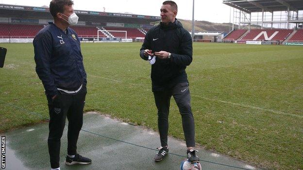 Referee Thomas Bramall explains his decision to Oxford United assistant coach Craig Short