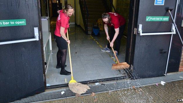 Staff mopping out flood water from the Arndale Centre in Eastbourne