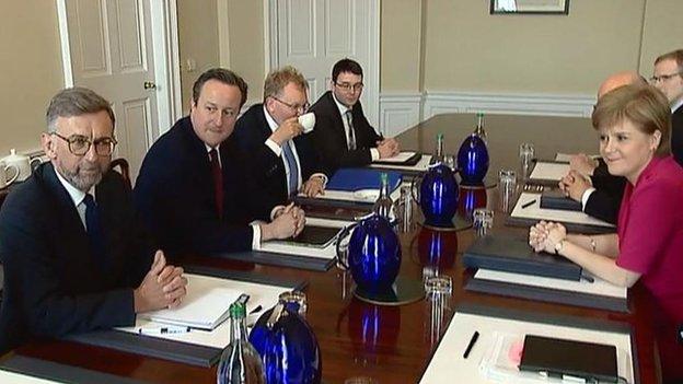 Andrew Dunlop, left, is pictured sitting next to David Cameron at a meeting with Nicola Sturgeon