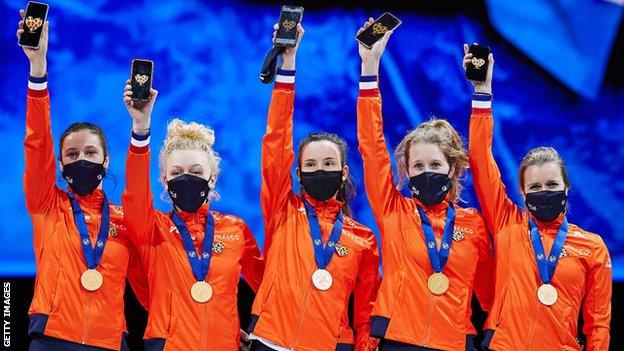 Team Netherlands held up heart pictures on their phones in memory of Lara van Ruijven at the World Short Track Speed Skating Championships in March 2021