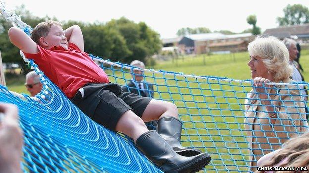 Child in hammock talking to Duchess of Cornwall