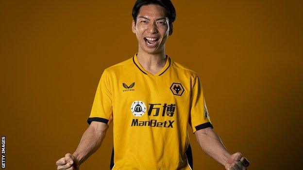 Hayao Kawabe celebrates in a Wolves shirt