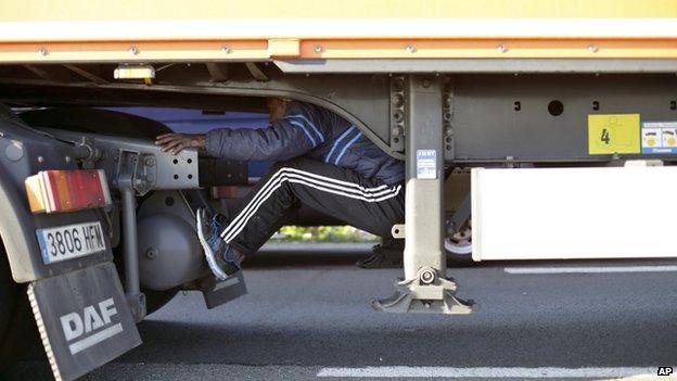 A migrant clinging to the underside of a lorry