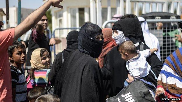 Syrian refugees wait at the Turkish border to go back to the northern Syrian town of Tal Abyad, June 17, 2015