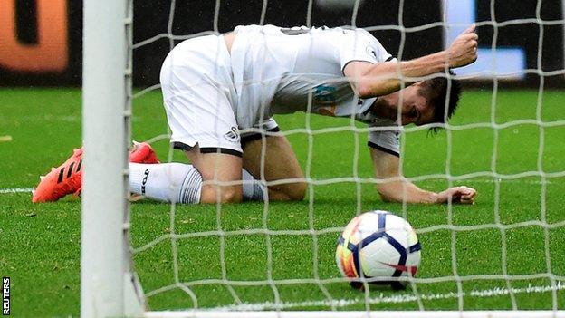 Federico Fernandez reacts after his own goal gives Leicester the lead