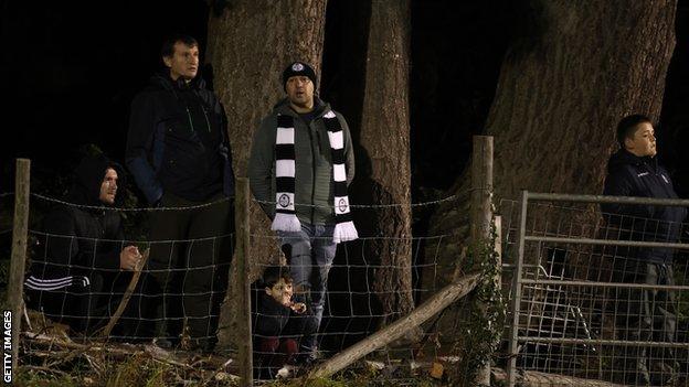 Fans behind a fence