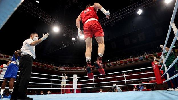 Aidan Walsh leaps into the air to celebrate his quarter-finals win at the Olympics