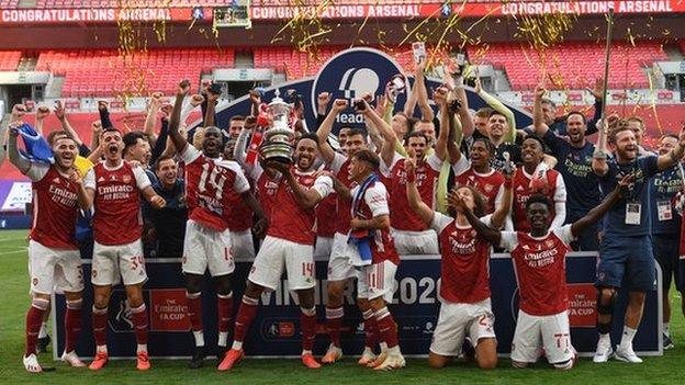 Arsenal players celebrate with the FA Cup trophy after beating Chelsea behind closed doors in the 2020 final at Wembley stadium