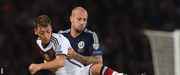 Defender Alan Hutton tussles with Mezut Ozil