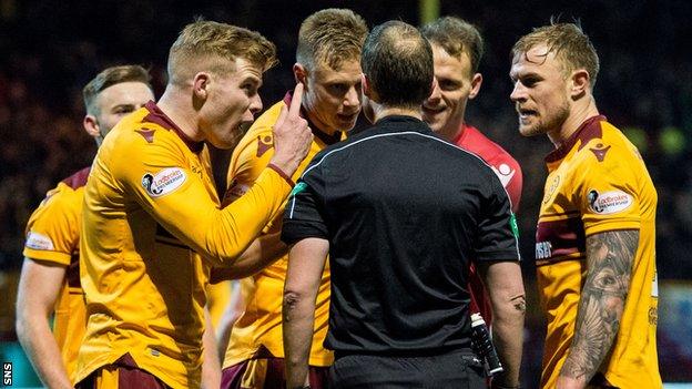 Motherwell players confront referee Willie Collum, after he awarded Celtic a controversial late penalty in the sides' draw