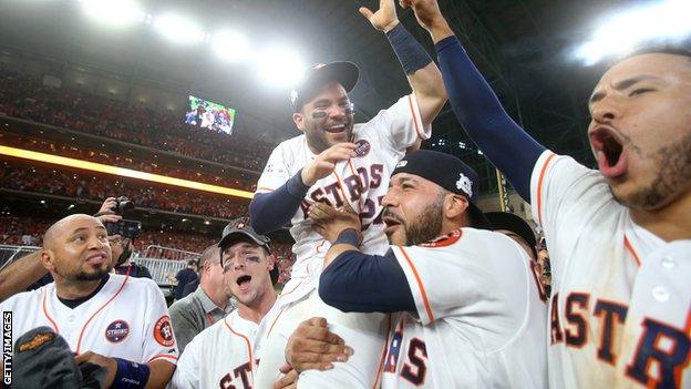 Houston Astros players hoist second baseman Jose Altuve on their shoulders