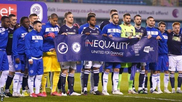 Millwall and QPR players holding an anti-racism banner before their game on 8 December 2020