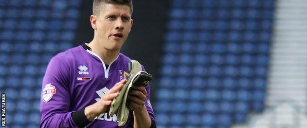 Alex Revell takes off his gloves after filling in as MK Dons keeper