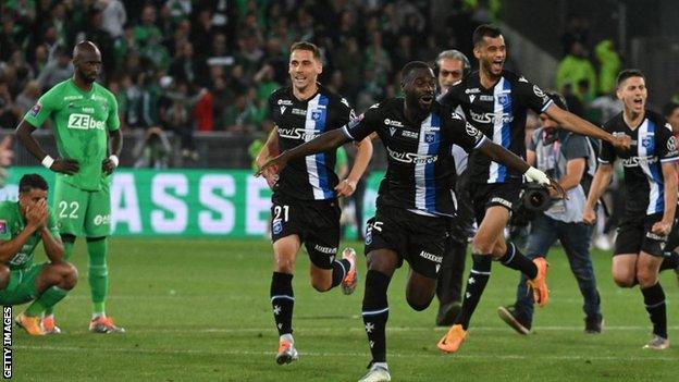 Auxerre's players celebrate their victory at the end of the French L1-L2 play-off second leg football match against Saint-Etienne