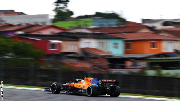 Lando Norris drives past the favelas of Sao Paulo