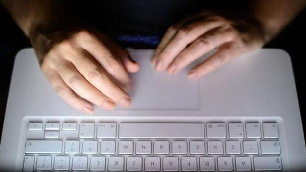 Hands typing on computer