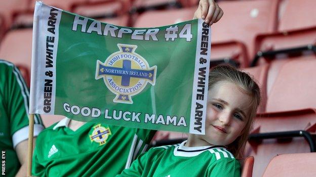 Harper holds a flag to support her mother