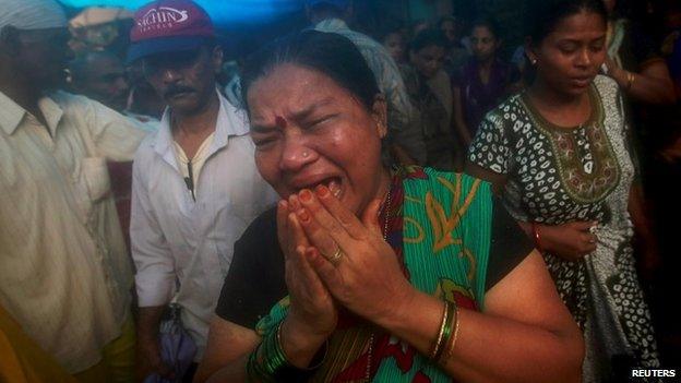 Wife of Mansingh, 52, who died after consuming bootleg liquor, cries outside their house in a slum in Mumbai, India, June 20, 2015.