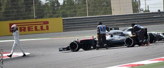 Jenson Button walking off track after a breakdown in practice