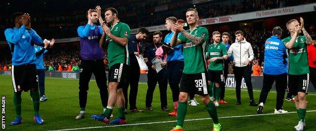 Lincoln players applaud the travelling fans after their defeat by Arsenal in the FA Cup