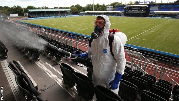 Technician disinfects seating area at Saracens