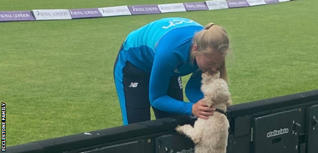 Sophie Ecclestone shares a moment with her dog Rex while on international duty with England