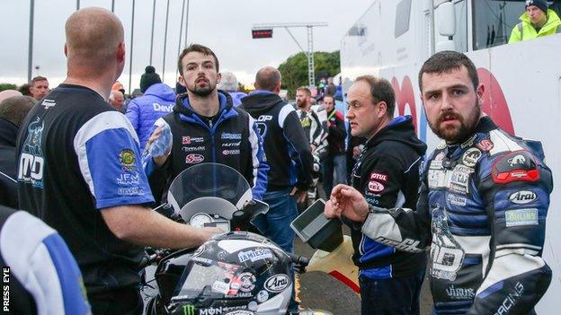 Michael Dunlop (right) waits in the paddock after the Dundrod 150 superbike race had to be red flagged