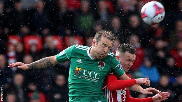 Cork's Karl Sheppard fights out an aerial duel with Derry's Eoin Toal