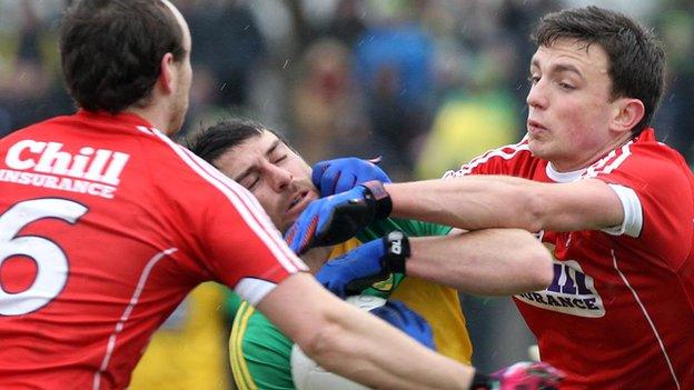 Donegal's Paddy McGrath is challenged by Cork duo Mark Collins and Brian O'Driscoll