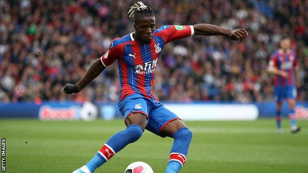 Crystal Palace forward Wilfried Zaha plays a pass during a Premier League game
